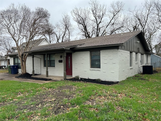 view of front of property featuring central AC unit and a front lawn