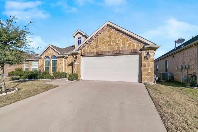 view of front of property featuring a garage, a front yard, and central air condition unit