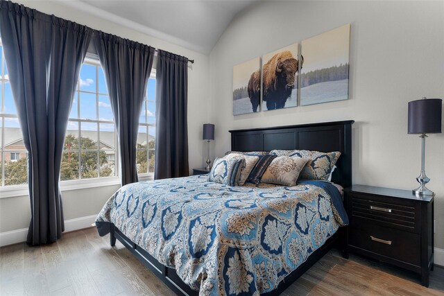 bedroom featuring lofted ceiling and hardwood / wood-style floors