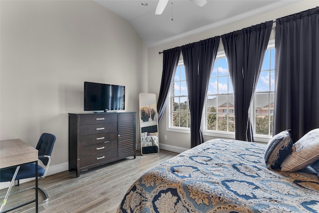 bedroom with ceiling fan, vaulted ceiling, and light hardwood / wood-style flooring