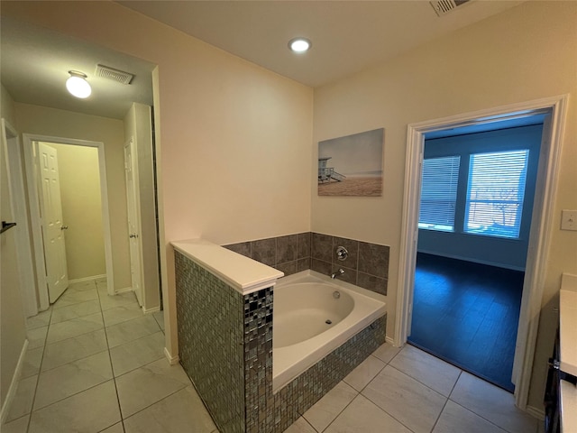 bathroom with tile patterned floors and tiled bath