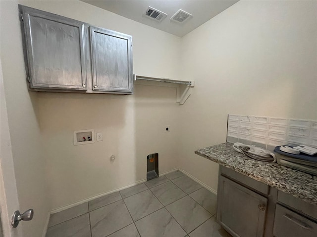 laundry room with gas dryer hookup, cabinets, washer hookup, light tile patterned floors, and electric dryer hookup