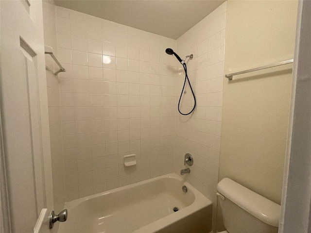 bathroom featuring toilet and tiled shower / bath combo