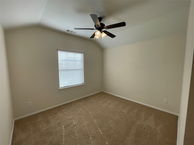 spare room with vaulted ceiling, carpet, and ceiling fan