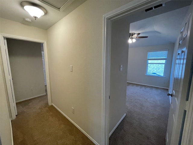 corridor featuring dark colored carpet