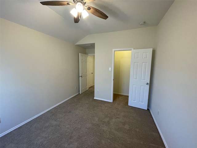 unfurnished bedroom with vaulted ceiling, ceiling fan, and dark colored carpet