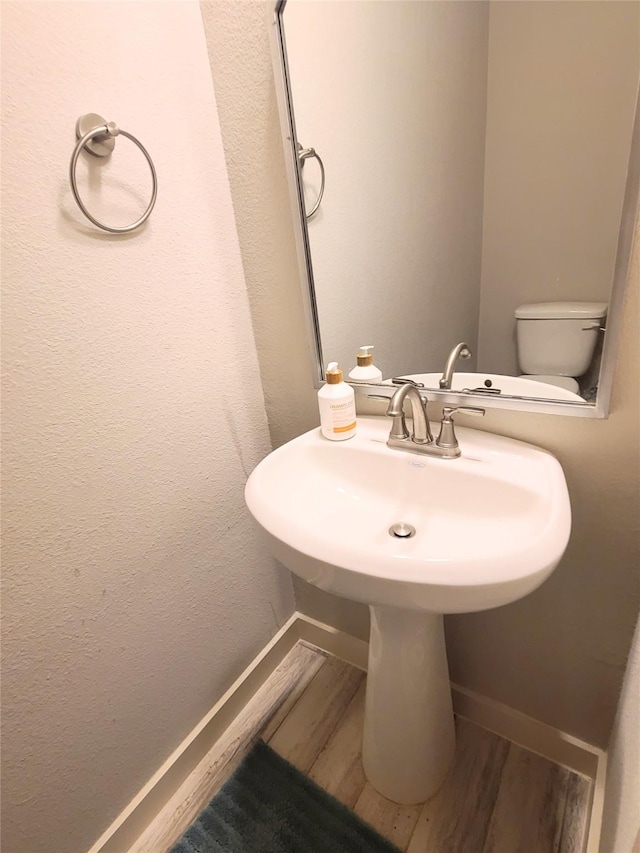 bathroom featuring hardwood / wood-style flooring and toilet