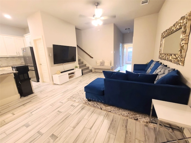 living room with ceiling fan and light wood-type flooring