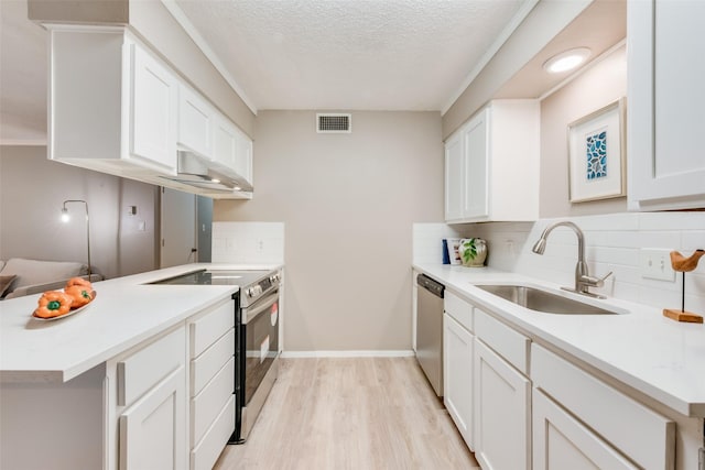 kitchen featuring white cabinetry, sink, kitchen peninsula, stainless steel appliances, and light wood-type flooring