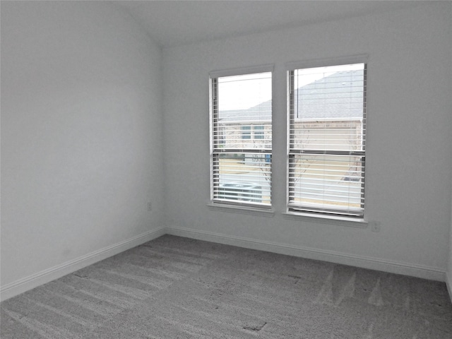 spare room featuring vaulted ceiling and carpet