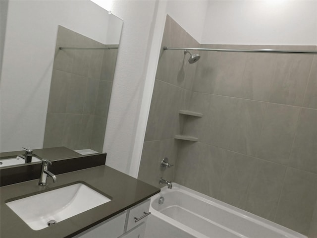 bathroom featuring tiled shower / bath and vanity