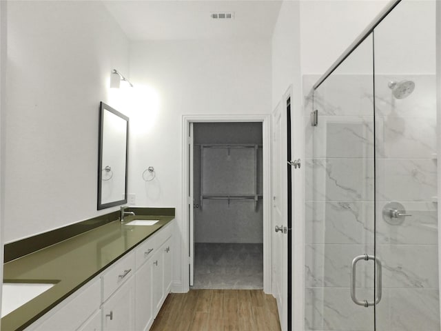 bathroom featuring vanity, a shower with shower door, and hardwood / wood-style floors