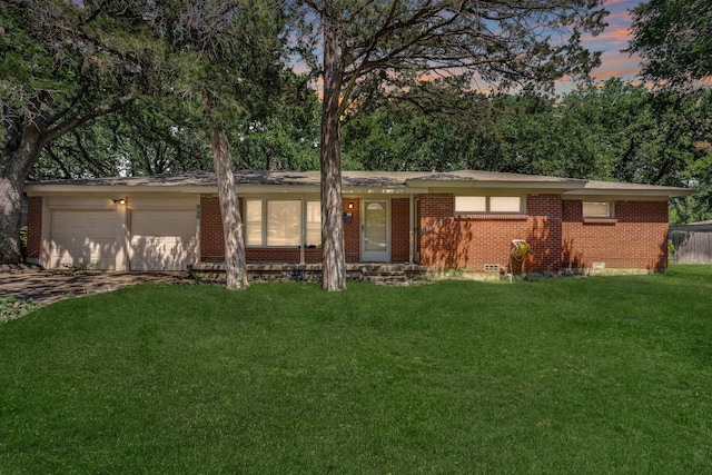 single story home featuring a garage and a lawn