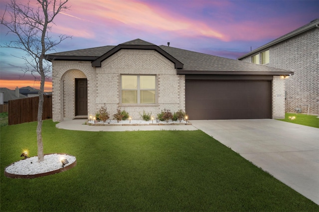 view of front of property featuring a garage and a lawn