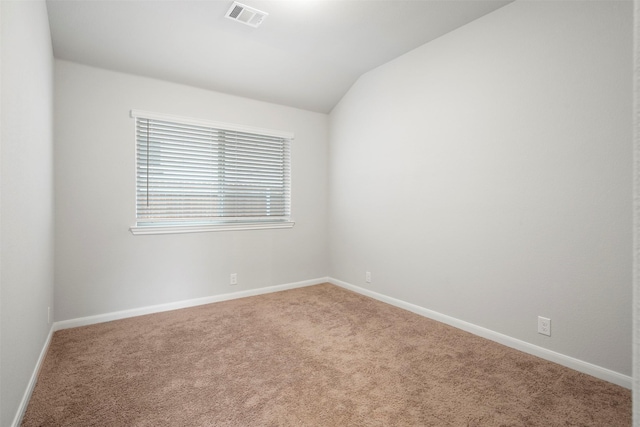 carpeted empty room with lofted ceiling