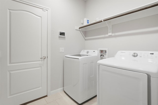 washroom featuring light tile patterned floors and washer and clothes dryer