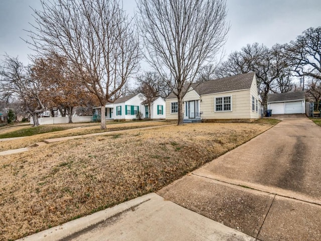 single story home with an outbuilding, a garage, and a front yard