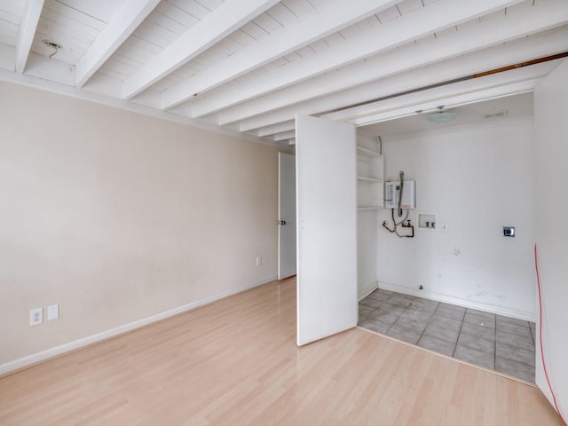 basement featuring light hardwood / wood-style flooring and water heater