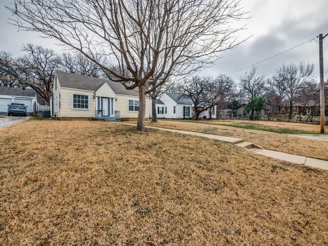 view of front of house with central AC and a front yard