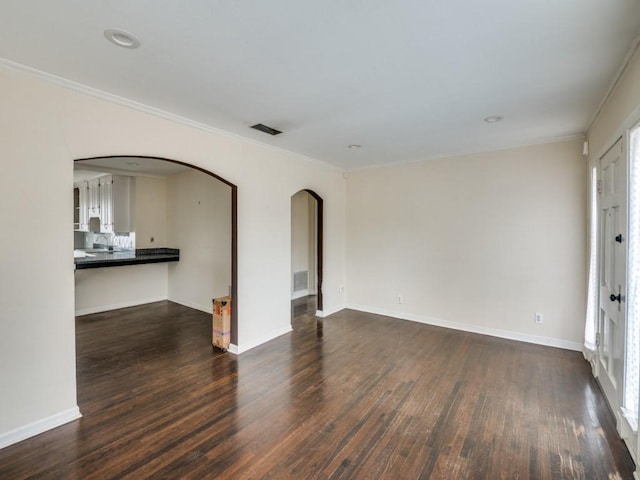 empty room featuring crown molding and dark hardwood / wood-style floors