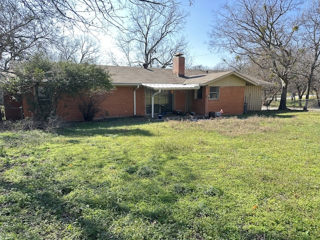 rear view of house featuring a yard