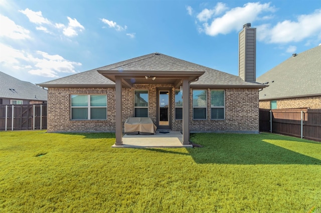 back of house with a yard and a patio