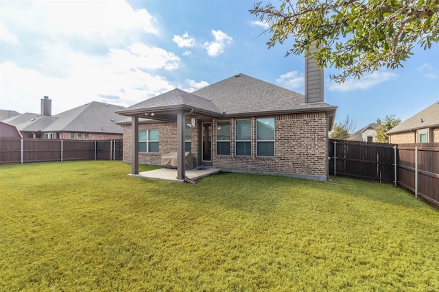 rear view of house featuring a yard and a patio area