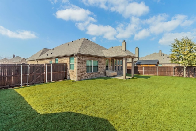 rear view of house with a lawn and a patio