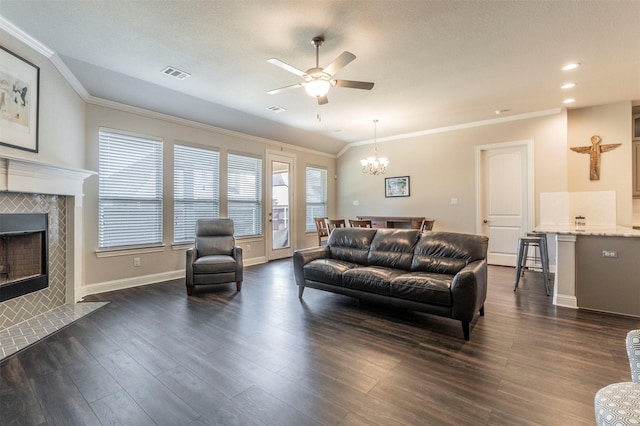 living room with crown molding, a fireplace, dark hardwood / wood-style floors, and ceiling fan with notable chandelier