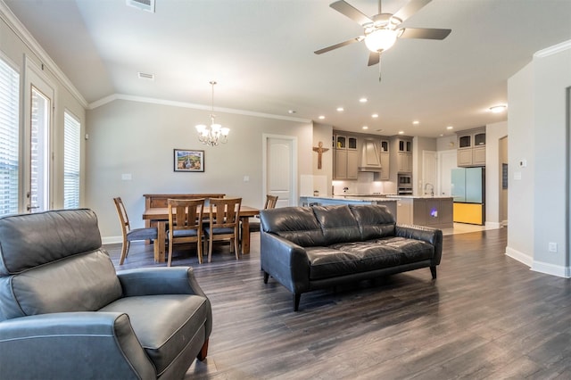 living room featuring ornamental molding, vaulted ceiling, dark hardwood / wood-style floors, and ceiling fan with notable chandelier