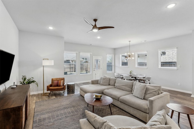 living room featuring dark hardwood / wood-style floors and ceiling fan with notable chandelier