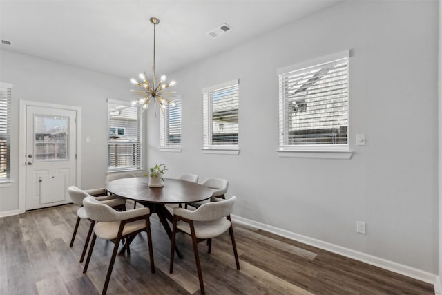 dining room with hardwood / wood-style floors and a chandelier