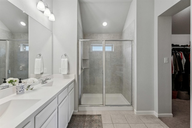 bathroom with tile patterned flooring, vanity, vaulted ceiling, and a shower with door