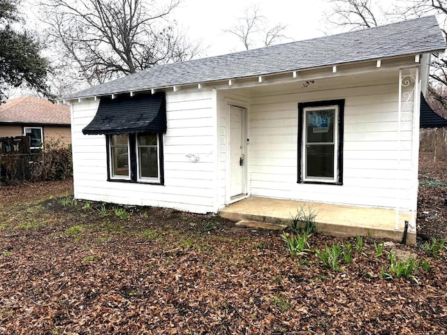 view of front of home featuring a shingled roof and fence