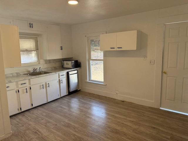 8112 Melrose St E, White Settlement, TX 76108 - kitchen featuring dishwasher, white cabinets, light countertops, and light wood-style flooring