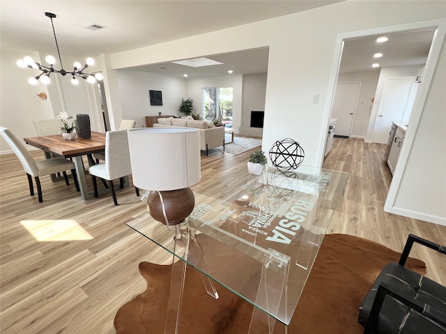 living room with a chandelier and light wood-type flooring