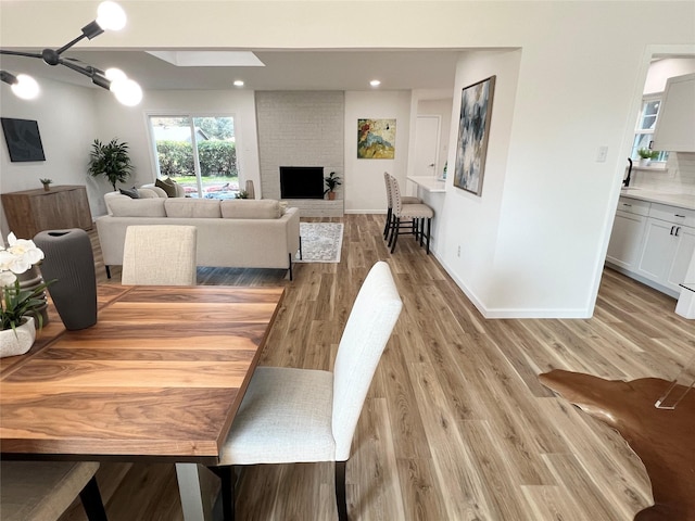 dining area featuring a fireplace and light hardwood / wood-style flooring