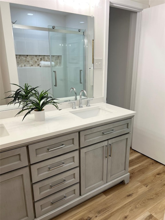 bathroom with vanity, hardwood / wood-style flooring, and walk in shower