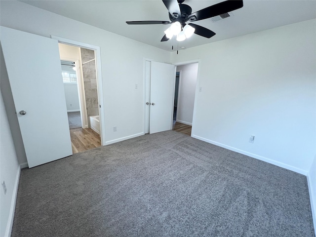 unfurnished bedroom with connected bathroom, ceiling fan, and carpet flooring