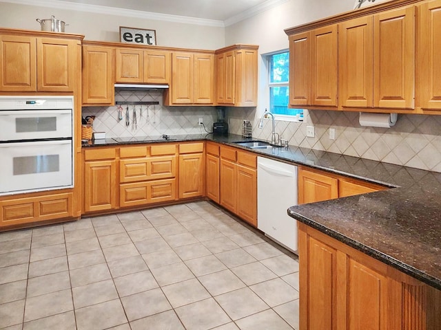 kitchen featuring sink, tasteful backsplash, ornamental molding, white appliances, and dark stone counters