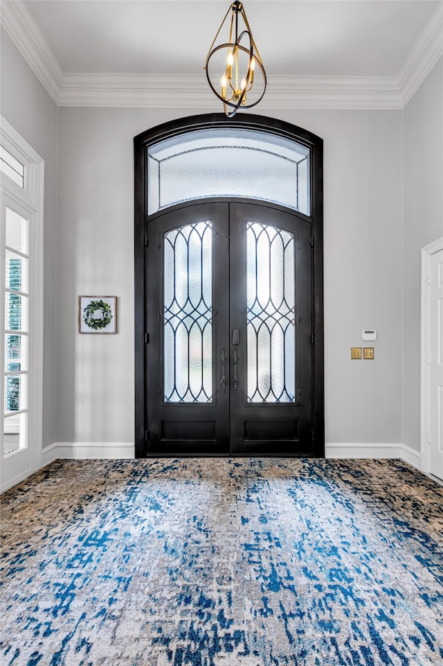 entrance foyer featuring ornamental molding, carpet, an inviting chandelier, and french doors