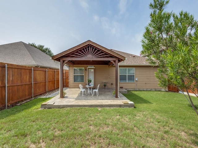 rear view of house featuring a yard and a patio area