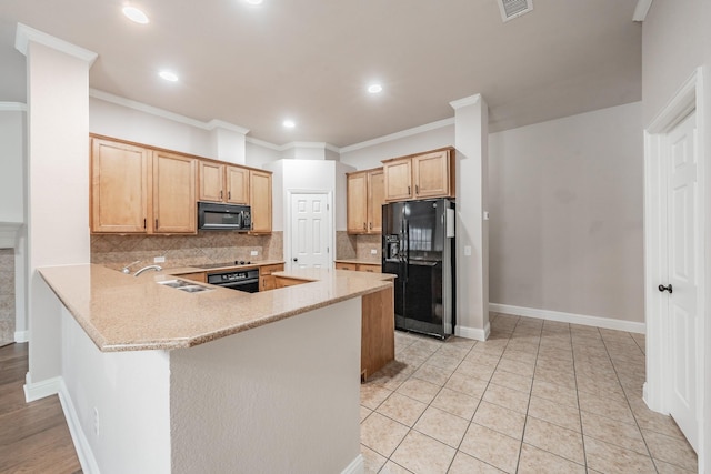 kitchen with black appliances, sink, decorative backsplash, light stone counters, and kitchen peninsula