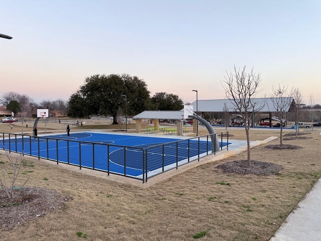 pool at dusk featuring a gazebo and basketball court