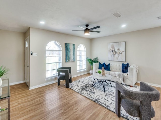 living room with light hardwood / wood-style flooring and ceiling fan