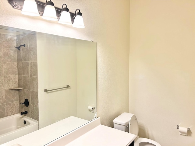 full bathroom featuring tiled shower / bath combo, vanity, and toilet