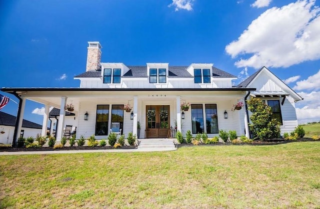 back of property with a yard and a porch