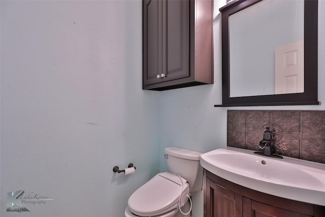 bathroom with vanity, toilet, and backsplash