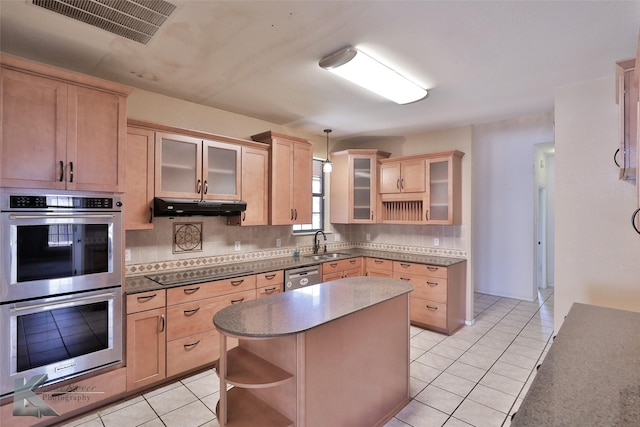 kitchen featuring a kitchen island, sink, decorative backsplash, light tile patterned floors, and stainless steel appliances