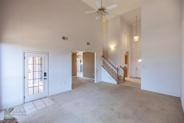 carpeted empty room featuring a high ceiling and ceiling fan